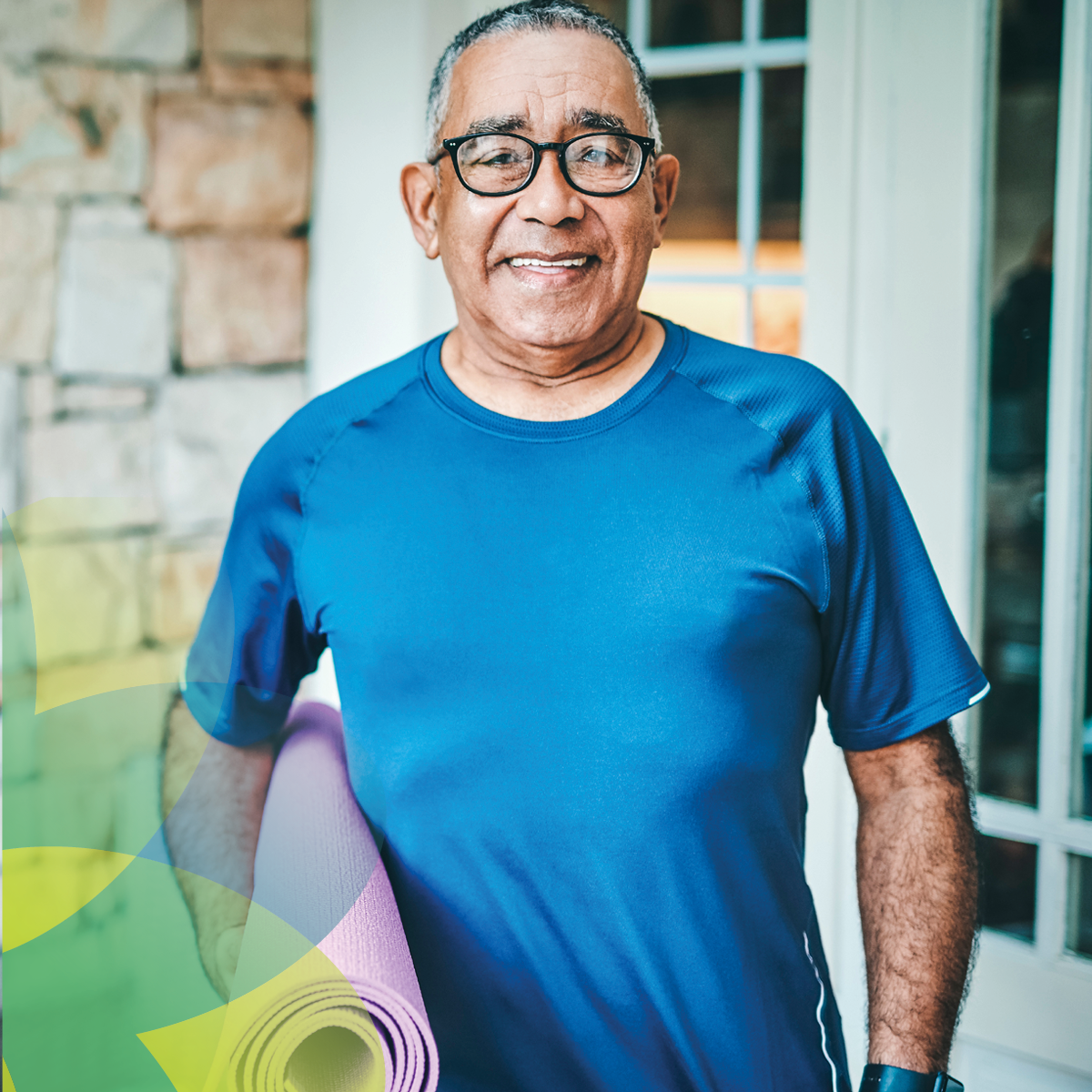 ChristianaCare My65+ ad featuring an older man wearing a blue workout shirt and holding a yoga mat, smiling confidently. The background shows a home environment with stone walls.